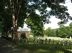 The small church and cemetery, behind the iron fence