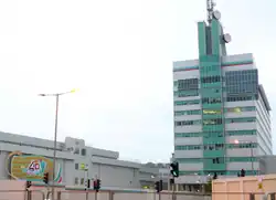 Modern, green-and-white building with dish antennas on top