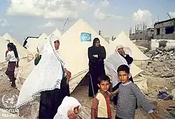 Women weep at the destruction of Khan Younis camp during the second intifada, 2001