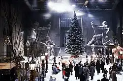 Film set with a tall evergreen tree and many people