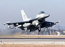 Jet heavily armed with weapons under wings taking off.