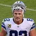 Headshot of Jason Witten on a football field in uniform with his helmet resting on top of his head