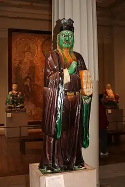 Figure of an assistant to the Judge of Hell decorated in polychrome enamels with cold-painted details; 1522–1620; painted and glazed earthenware; height: 136&nbsp;cm, width: 39&nbsp;cm; British Museum