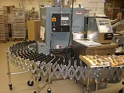Bakery goods shrinkwrapped by shrink film, heat sealer and heat tunnel on roller conveyor