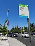 Bus stop sign at a stop featuring a bus bulb curb